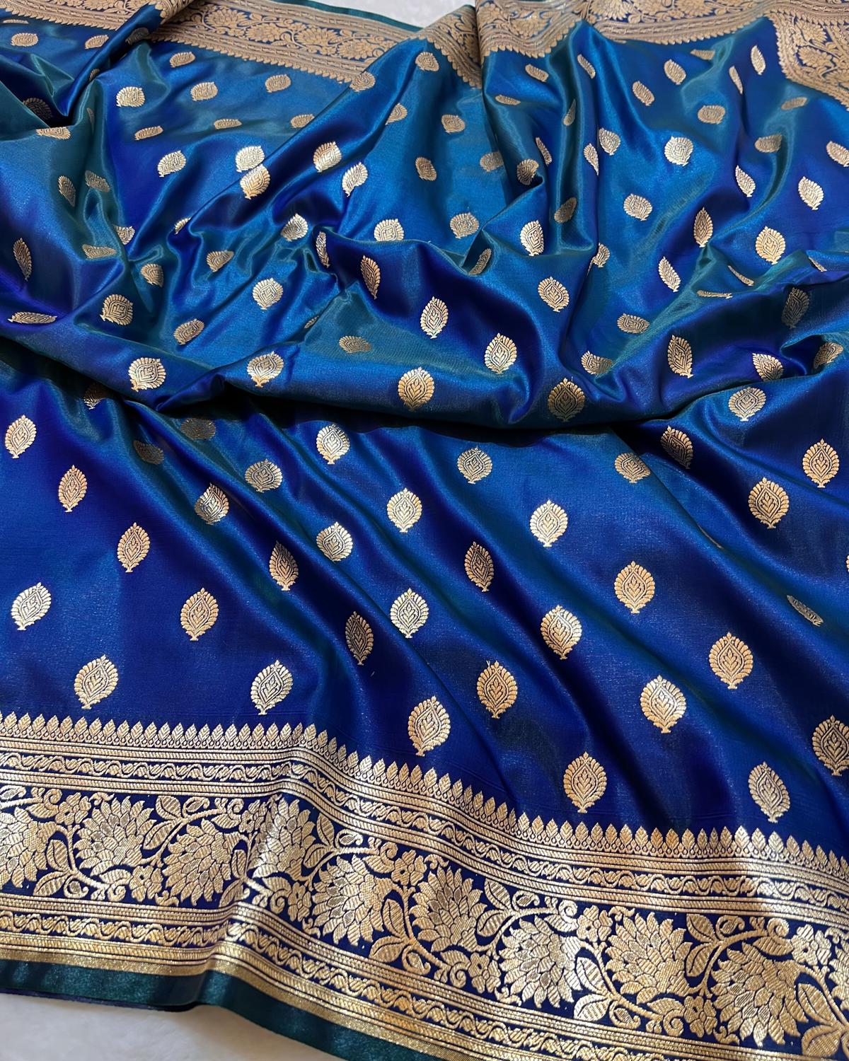 Blue saree with gold polka dots and border on a white background